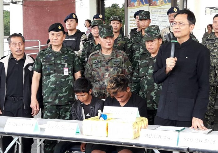 Police and military officers bring two drug suspects to a news conference on June 14 in Chiang Mai province.