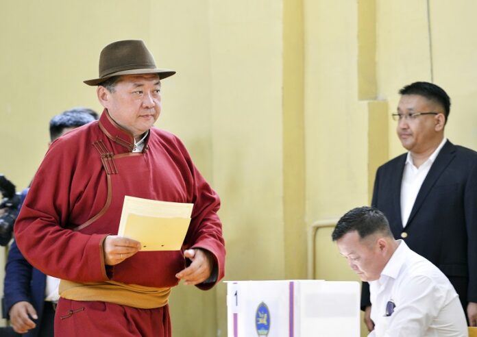 Speaker of Parliament and Mongolian People's Party presidential candidate Miyegombo Enkhbold, left, casts his vote at a polling station Monday at a school in Ulaanbaatar, Mongolia. Photo: Chadraabal Baramsai / Associated Press
