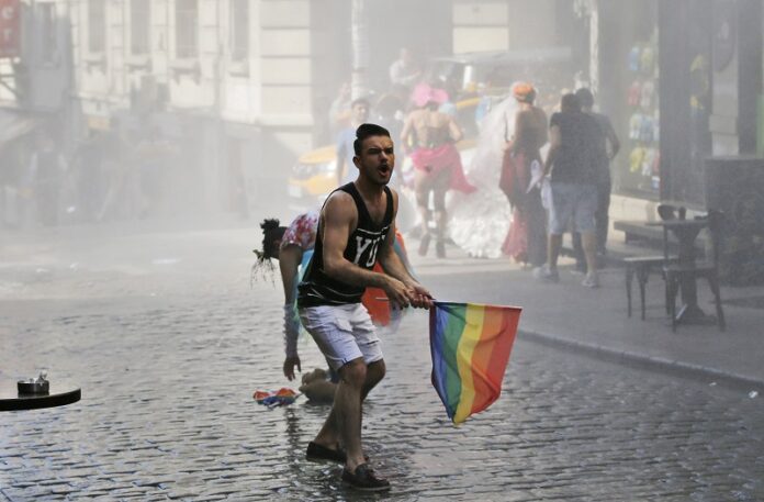 A participant of the Pride Week march in 2015 in Istanbul, reacts as others flee after Turkish police use a water canon to disperse them. Photo: Emrah Gurel / Associated Press