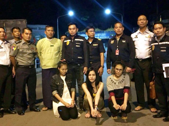 Three murder suspects are lined up to take photos with Thai authorities Saturday night after they were handed over from Myanmar.
