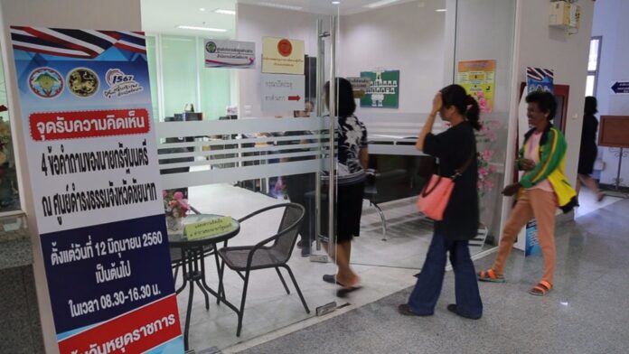 Members of the public line up at a government center Monday to submit their answers to junta chairman Prayuth Chan-ocha’s four questions in Chai Nat province