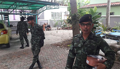 A soldier, at right, holds a box of biscuits given by Chanoknan's parents during a Jan. 12 visit to their home. Photo: Chanoknan Ruamsap / Courtesy