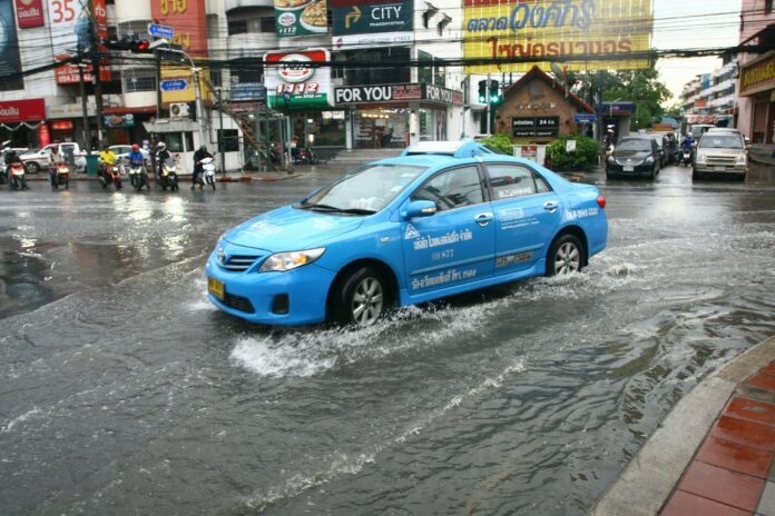 A taxi navigates a partially flooded street June 5 near the Wongsakorn Market on Sai Mai Road in Bangkok.