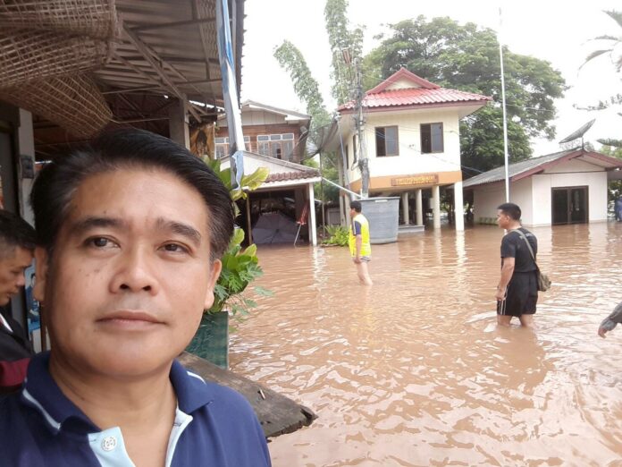 A resident of Loei province takes a flood selfie Tuesday afternoon.