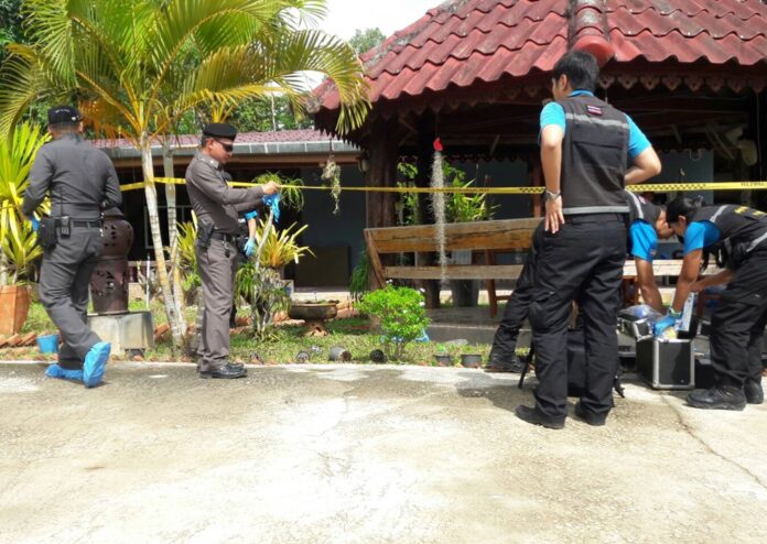 Investigators comb the residence of murdered village administrator Worayuth Sanlang in Krabi province Tuesday