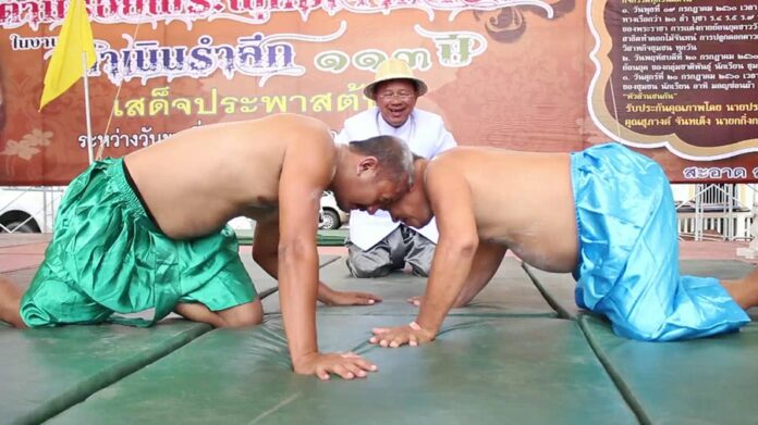 Ratchaburi natives Anthapol Supcharoen, 38 at left, and Weeradech Ittilup, 63, wrestle their bald heads Monday in Ratchaburi province.