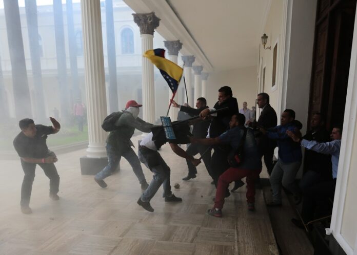 Opposition lawmakers brawl with pro-government militias who are trying to force their way into the National Assembly during a special session coinciding with Venezuela’s independence day, Wednesday in Caracas, Venezuela. Photos: Fernando Llano / Associated Press