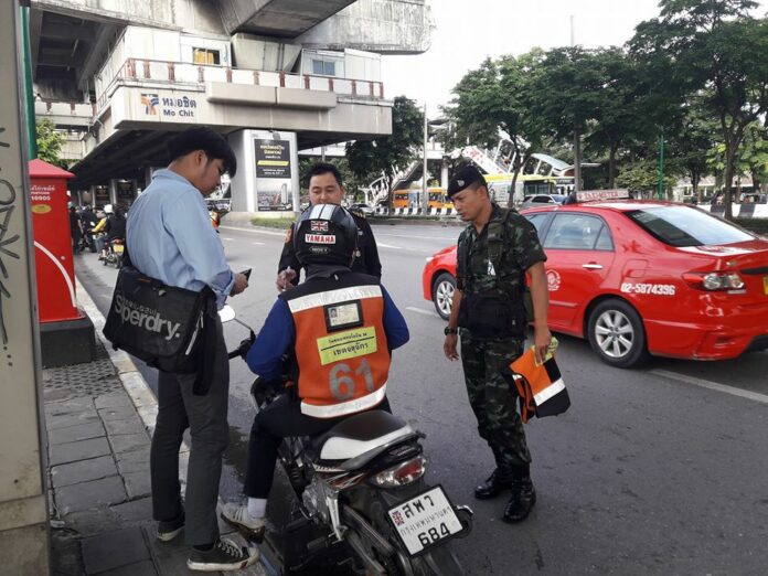 Police and military officers detain a motorbike taxi operator in July. Photo: Fm91trafficpro / Twitter