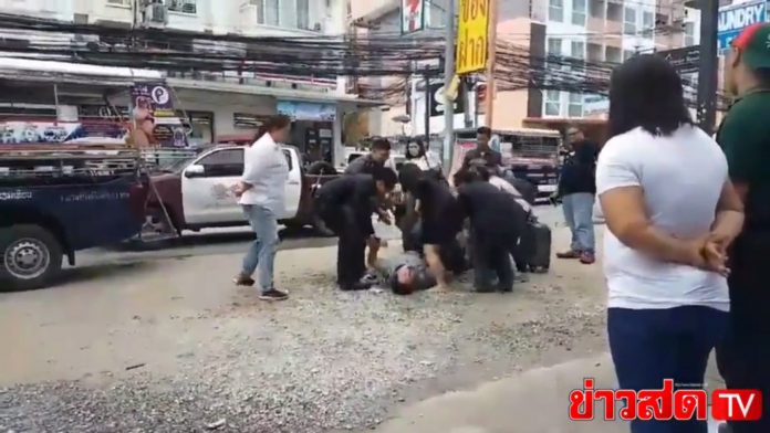 A man screams on the ground Tuesday in Pattaya after he was reportedly denied his meal of choice.