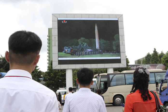 People watch a news broadcast on a missile launch Saturday in Pyongyang, North Korea. Photo: Jon Chol Jin / Associated Press