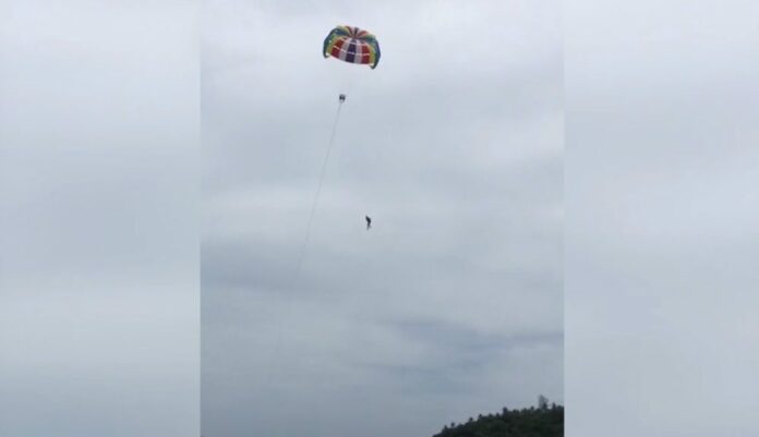 A screenshot from video shows the moment an Australian man fell to his death from a parasail on Phuket’s Kata Beach.