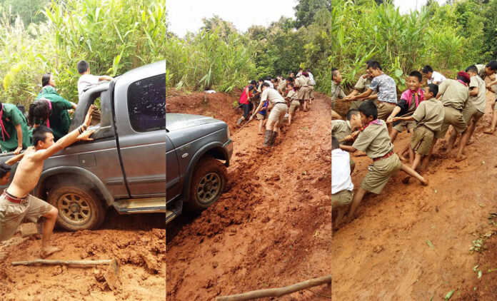 Students from Ban Huai Wok School on Wednesday drag their school director’s truck up a muddy hillside in Mae Mong Son province.