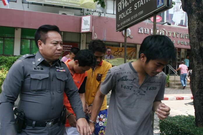 Police escort the men accused of killing Somkiat Srichan to court on May 3, 2016.