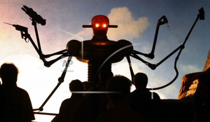 An Aug. 1, 2000 file photo, visitors of the world exhibition Expo 2000 stand in front of a robot display at the