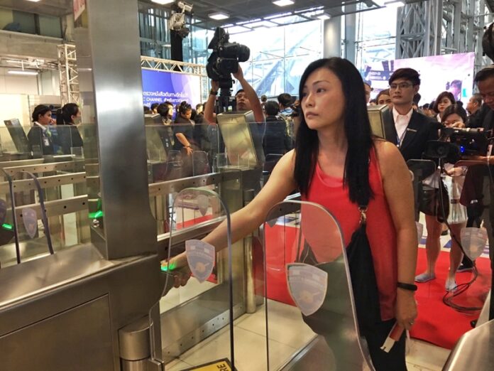 A Singaporean woman uses an automated immigration gate Saturday at Suvarnabhumi Airport.
