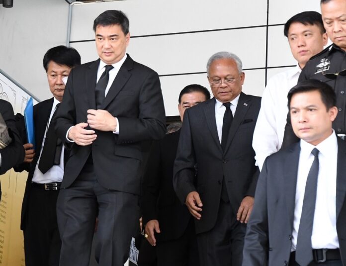 Former Prime Minister Abhisit Vejjajiva, at left, and his former deputy Suthep Thaugsuban, fourth from right, depart Thursday from the Supreme Court in Bangkok.