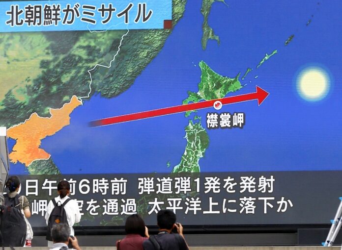 People walk by a TV news program reporting North Korea's missile launch Tuesday in Tokyo. Photo: Shizuo Kambayashi / Associated Press