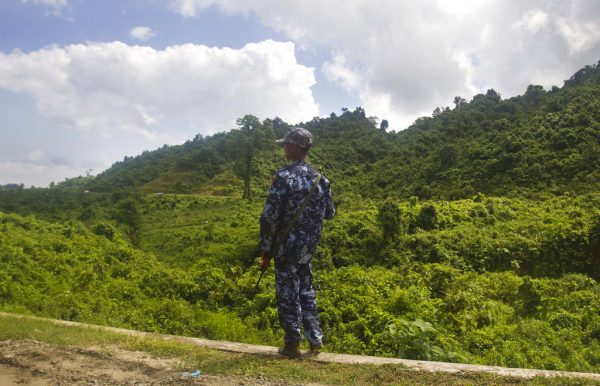 A Myanmar police officer stands on a road as they provide security at a checkpoint on May 28, 2017, in Buthidaung, Rakhine State, western Myanmar. Photo: Associated Press