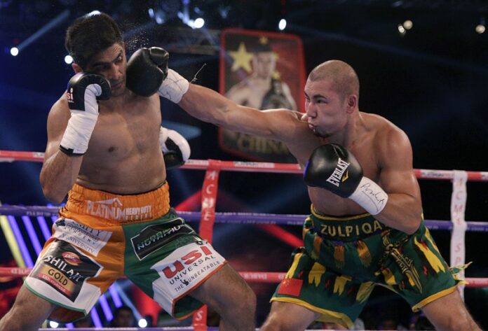 Indian boxing and WBO Asia-Pacific Super Middleweight champion Vijender Singh, left, fights with WBO Oriental Super Middleweight champion of China Zulpikar Maimaitiali, right, Saturday during their fight for the double title in Mumbai, India. Photo: Rafiq Maqbool / Associated Press
