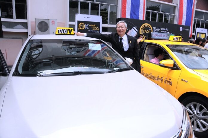 Pichit Akrathit, deputy transport minister, poses Thursday with a car registered for use in the forthcoming government-run Taxi VIP service.