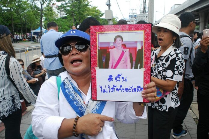 A supporter holds a portrait of former Prime Minister Yingluck Shinawatra on Friday outside the supreme court in Bangkok.