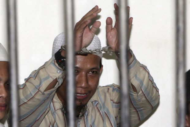 A photo file of Aman Abdurrahman as he raises his hands in a holding cell while awaiting trial in Jakarta in 2010