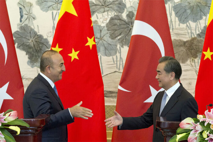 Chinese Foreign Minister Wang Yi, at right, shakes hands with Turkish Foreign Minister Mevlut Cavusoglu after a joint news conference Thursday in Beijing. Photo: Ng Han Guan / Associated Press