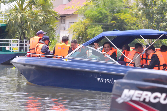 Gen. Prayuth Chan-ocha on a boat in a flooded area in Sakhon Nakhon Wednesday.