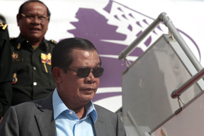 Cambodian Prime Minister Hun Sen, in foreground, exits a plane as his arrives from a trip to Laos at the airport in 2017 in Phnom Penh. Photo: Heng Sinith / Associated Press