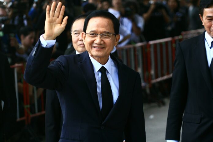 Former Prime Minister Somchai Wongsawat waves outside the court Wednesday morning.