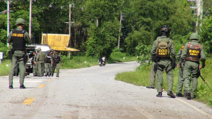 Authorities inspect the scene where the two bomb exploded Thursday in Yala province, killing two officers.