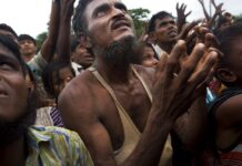 UN Expert Warns of ‘Rushed Plans’ to Repatriate Rohingya A Rohingya man stretches his arms out for food distributed by local volunteers, with bags of puffed rice stuffed into his vest in 2017 at Kutupalong, Bangladesh. Photo: Bernat Armangue / Associated Press