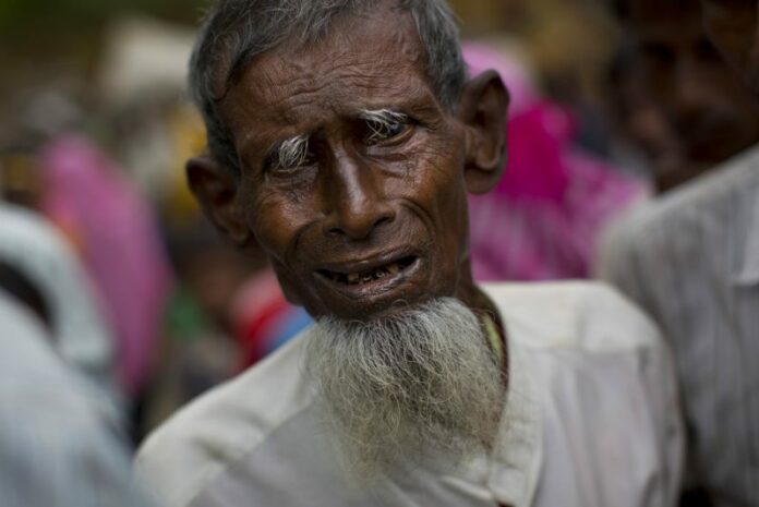 An elderly Rohingya Muslim, who recently crossed over from Myanmar into Bangladesh, arrives at a food distribution center on Sept. 9 in Kutupalong, Bangladesh. Photo: Bernat Armangue / Associated Press