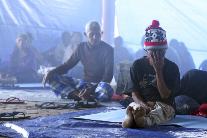 Villagers sit in a temporary shelter in Bali, Indonesia, Saturday, Sept. 23, 2017. Indonesian authorities raised the alert level for the Mount Agung volcano on the tourist island to the highest level, and more than 11,000 villagers left their homes around the mountain, officials said Friday. Photo: Firdia Lisnawati / Associated Press
