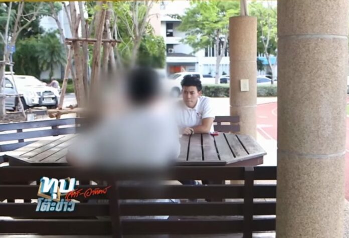 A Silpakorn University student who alleges being forced to strip, shower with senior classmates and touch another student's genitals speaks to a television reporter Sunday. Image: Amarin TV