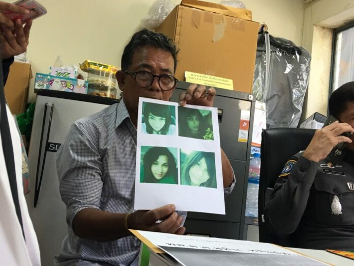 Anant Saengurai, 63, holds up photos of his missing daughter Nantiya Saengurai on Friday at the Bang Bua Thong Police Station in northern metro Bangkok.