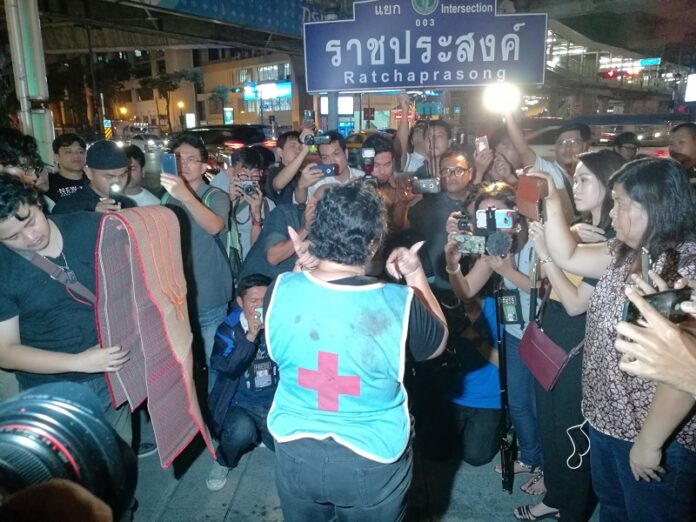 At a vigil Thursday, Phayaw Akkahad, at center facing away, wears the vest her daughter was killed in May 22, 2010, while tending to injured protesters at a Bangkok temple.
