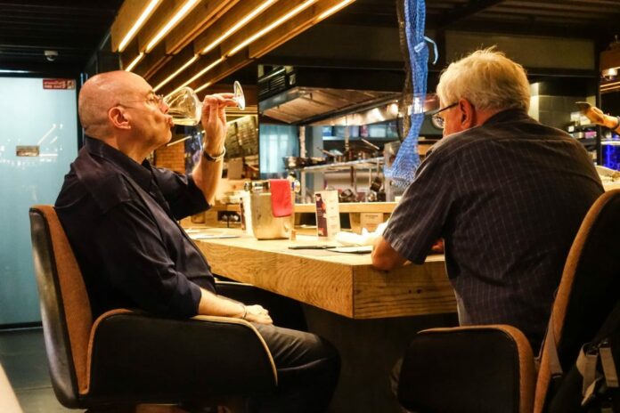 Customers drink wine in June at a Bangkok restaurant.