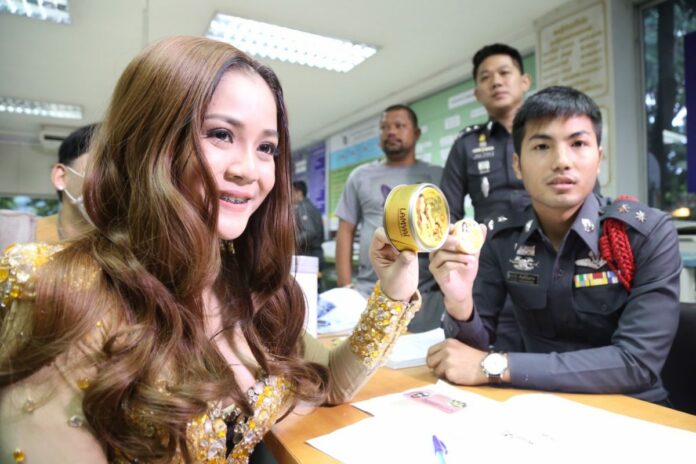 Lamyai Hai Thongkam and a Thonglor police officer on Monday both display tins of her face soap brand.