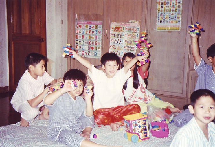 baby I am front left with blue pajamas and toys covered face