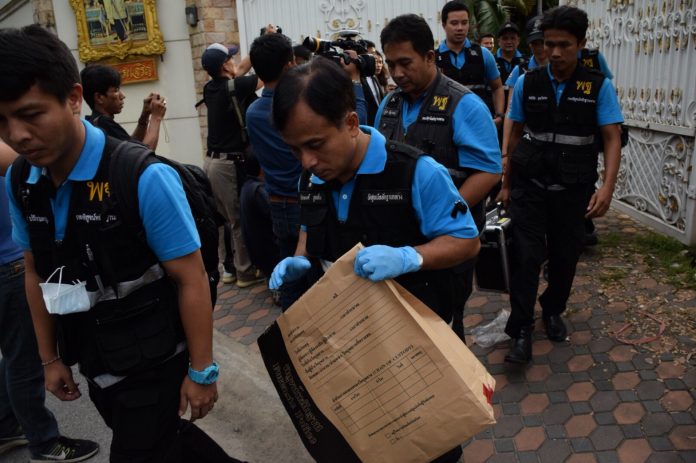 Forensic police officers leave Yingluck Shinawatra’s residence with an evidence bag Thursda