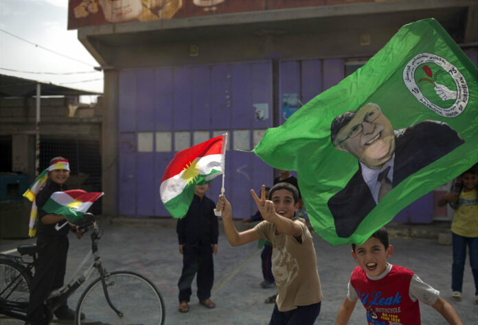 Children holding Kurdish flags run in the streets Monday in the disputed city of Kirkuk. Photo: Bram Janssen / Associated Press