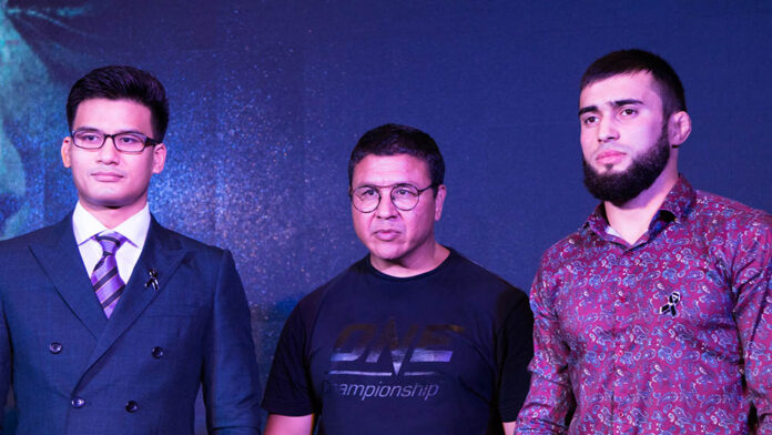 One Championship MMA's Shannon “OneShin” Wiratchai, at left, will face off against Russian Rasule Yakhyaev, at right in December. At center is ONE's Thailand President Kamol “Sukie” Sukosol Clapp on stage at a Thursday presser in Bangkok.