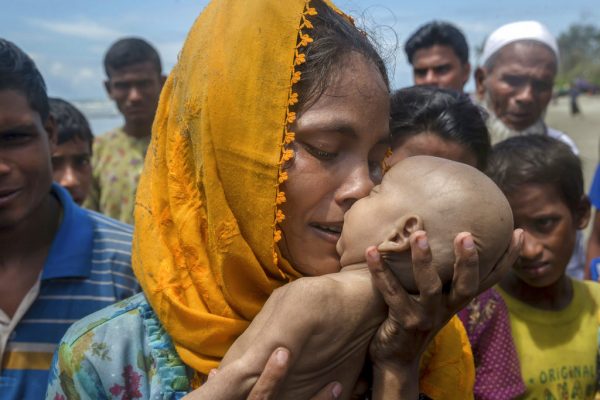 Rohingya Muslim woman Hanida Begum, who crossed over from Myanmar into Bangladesh, kisses her infant son Abdul Masood who died when the boat they were traveling in capsized just before reaching the shore of the Bay of Bengal in 2017 in Shah Porir Dwip, Bangladesh. Photo: Dar Yasin / Associated Press