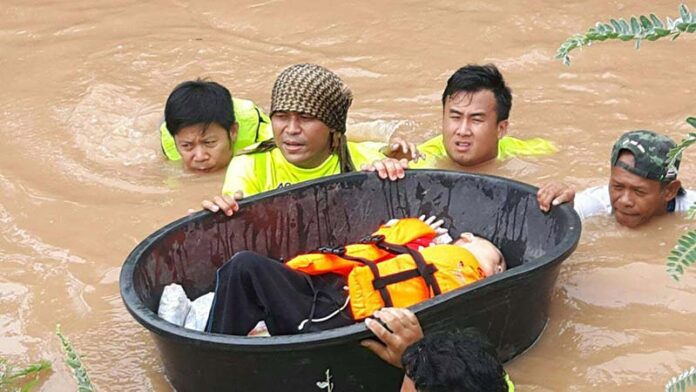 Emergency officials rescue a child using ropes and large buckets after he and his family were flooded in for two days Sunday in Phitsanulok province.