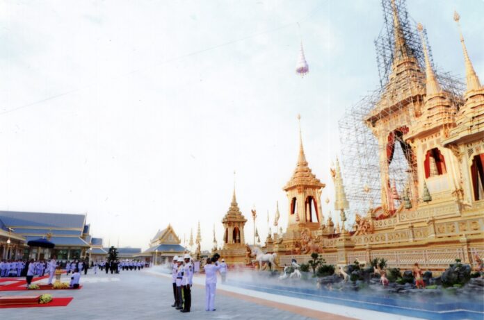 A multi-tiered umbrella is hoisted to the top of the funerary structure on Wednesday evening at Bangkok’s Sanam Luang.