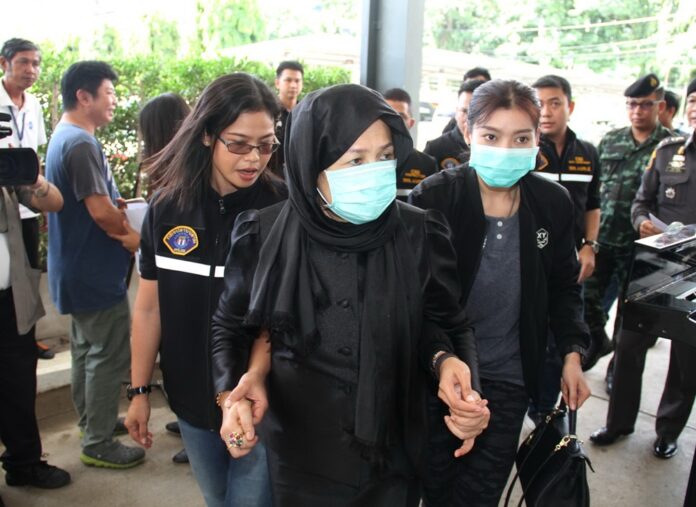 A suspect accused of fraud with Hajjee Company is brought to a police station on Wednesday