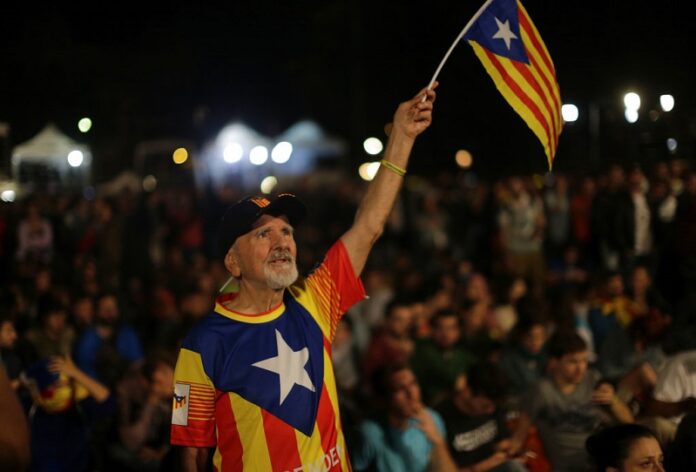 A man waves a ''estelada'' or Catalonia independence flag during a gathering Sunday at Plaza Catalonia in Barcelona, Spain. Photo: Emilio Morenatti / Associated Press