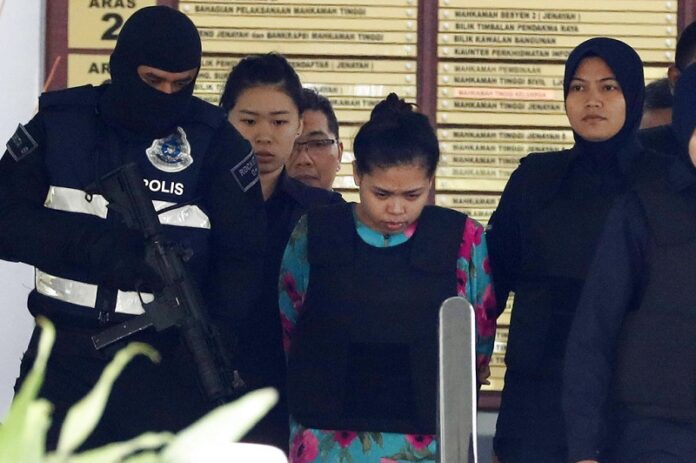 Siti Aisyah of Indonesia, center, is escorted by police as she leaves the court house Tuesday in Shah Alam, Malaysia. Photo: Vincent Thian / Associated Press