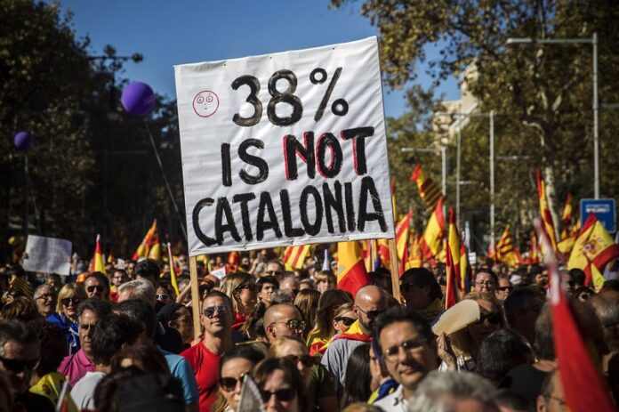 Nationalist activists hold up a banner during a mass rally against Catalonia's declaration of independence,Sunday in Barcelona, Spain. Photo: Santi Palacios / Associated Press